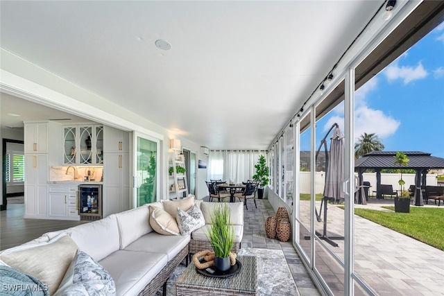 sunroom featuring wine cooler and bar area