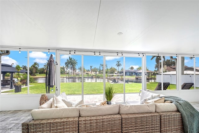 sunroom / solarium featuring a water view and a healthy amount of sunlight