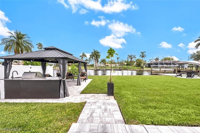 view of community featuring a patio, a water view, fence, a yard, and a gazebo