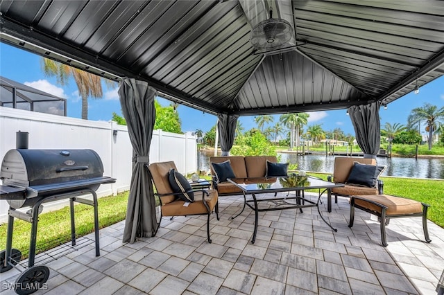 view of patio with a water view, a gazebo, grilling area, and an outdoor living space