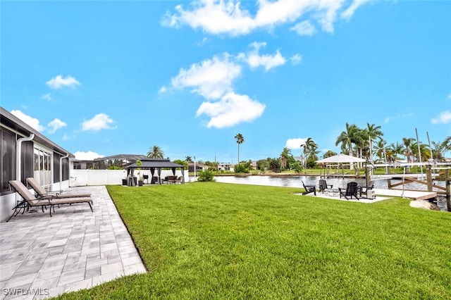 view of yard featuring a water view, a patio area, and a gazebo