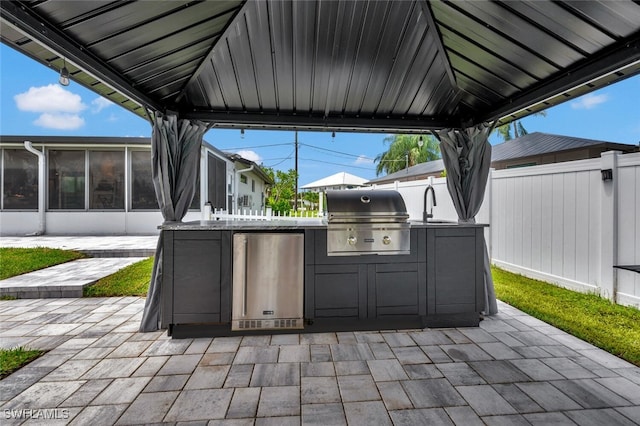 view of patio / terrace with grilling area, sink, and an outdoor kitchen