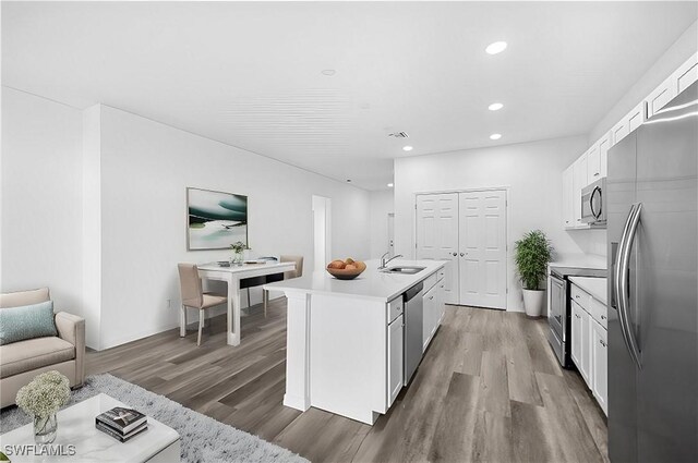 kitchen featuring a kitchen island with sink, dark wood-type flooring, white cabinets, sink, and appliances with stainless steel finishes