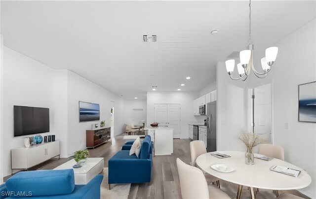 dining area featuring hardwood / wood-style floors and a notable chandelier