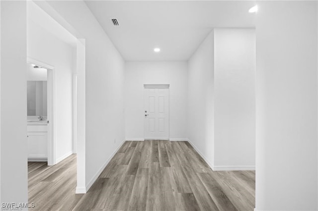 corridor with sink and light hardwood / wood-style flooring