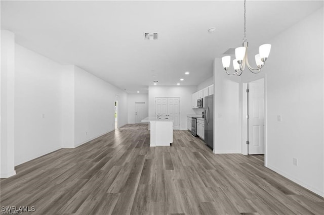 kitchen featuring a center island, white cabinets, dark hardwood / wood-style floors, decorative light fixtures, and stainless steel appliances