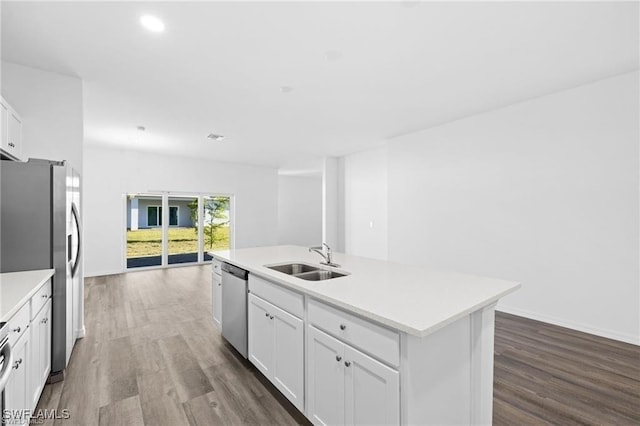 kitchen with stainless steel appliances, sink, hardwood / wood-style floors, white cabinetry, and an island with sink