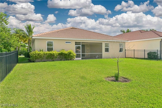 rear view of property featuring a lawn