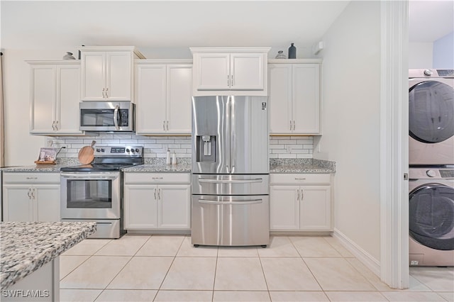 kitchen with appliances with stainless steel finishes, decorative backsplash, and light tile patterned flooring