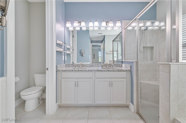 bathroom featuring tile patterned flooring, double sink vanity, a shower with shower door, and toilet