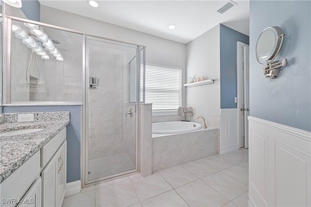 bathroom with tile patterned flooring, independent shower and bath, and vanity