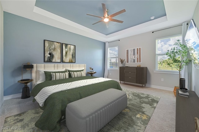 bedroom featuring ceiling fan, carpet, and a raised ceiling