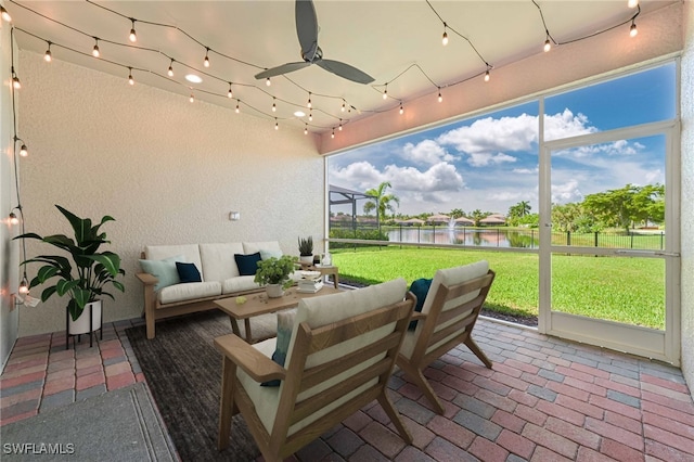 sunroom / solarium with ceiling fan and a water view