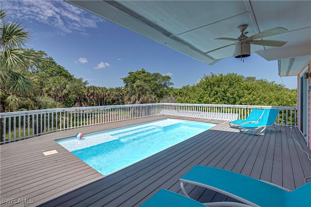 view of swimming pool with a wooden deck and ceiling fan