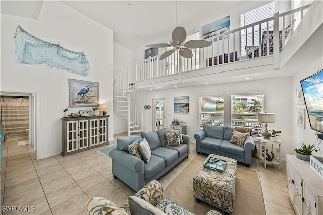 living room with ceiling fan, light tile patterned floors, and a towering ceiling