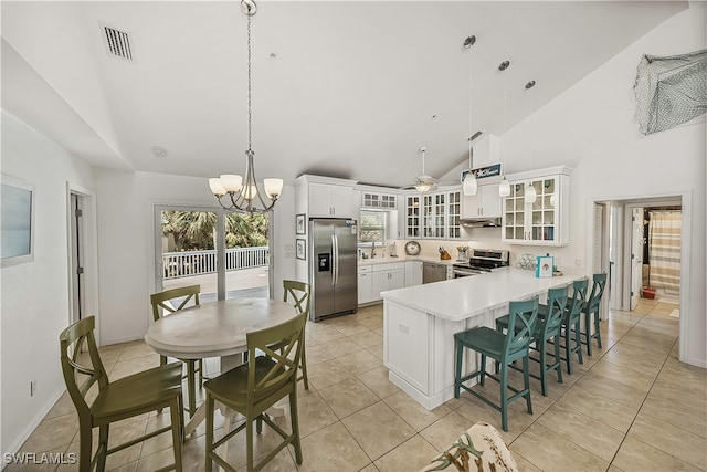 kitchen featuring decorative light fixtures, light tile patterned floors, stainless steel appliances, and white cabinetry