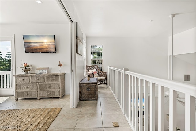 hall with light tile patterned flooring and a healthy amount of sunlight