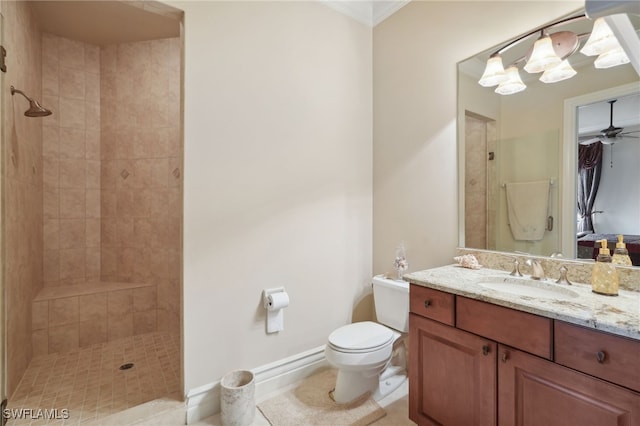 bathroom with vanity, tiled shower, crown molding, and toilet