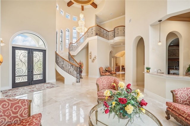 foyer entrance with crown molding, french doors, and a high ceiling