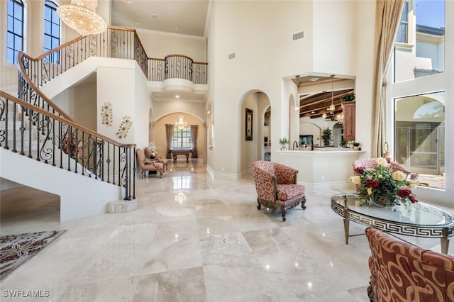 entrance foyer with visible vents, baseboards, stairs, arched walkways, and marble finish floor