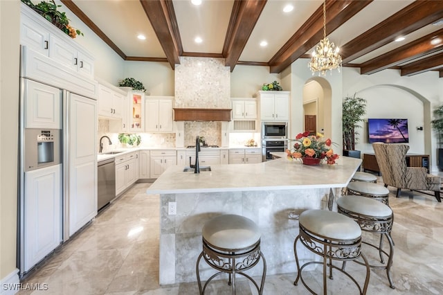 kitchen featuring tasteful backsplash, built in appliances, light countertops, custom exhaust hood, and a sink