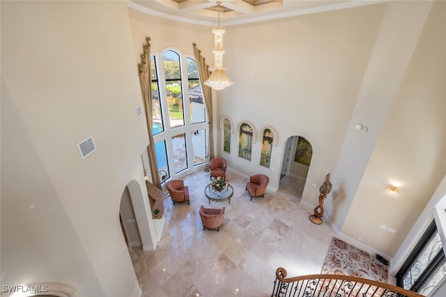 interior space featuring visible vents, baseboards, a high ceiling, arched walkways, and coffered ceiling