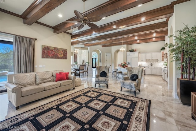 living room featuring ceiling fan with notable chandelier, arched walkways, marble finish floor, and ornamental molding