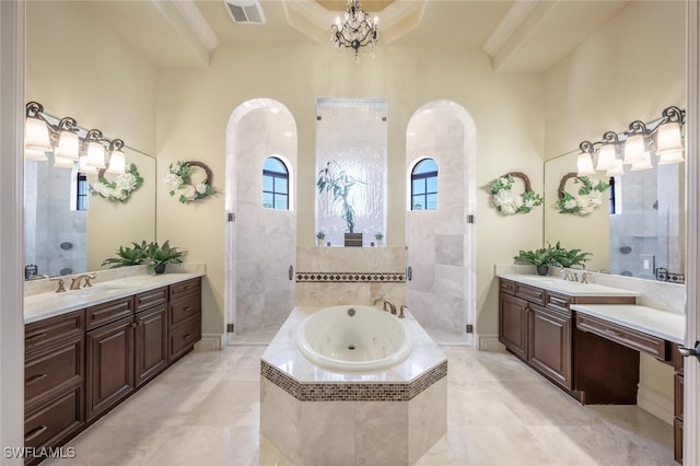 bathroom featuring a chandelier, visible vents, a garden tub, and two vanities