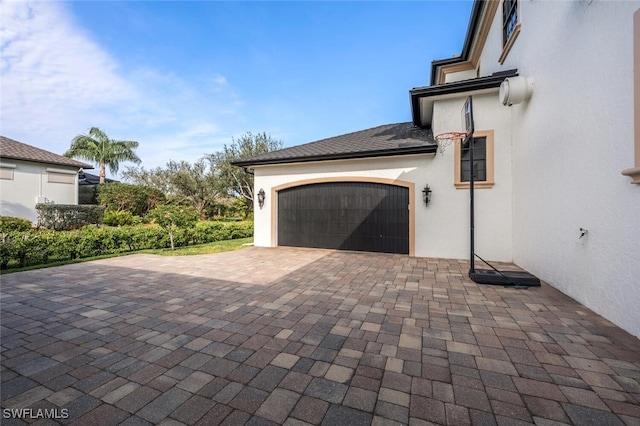 view of patio with decorative driveway and a garage