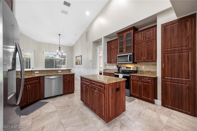 kitchen featuring a chandelier, appliances with stainless steel finishes, light stone counters, decorative light fixtures, and a center island