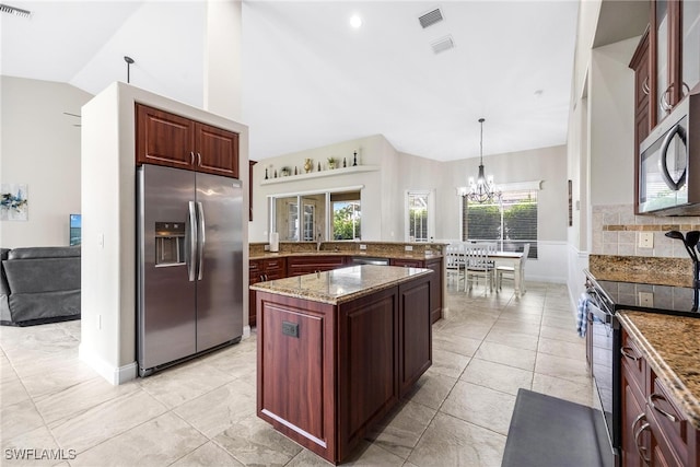 kitchen with light tile patterned flooring, appliances with stainless steel finishes, a center island, and pendant lighting