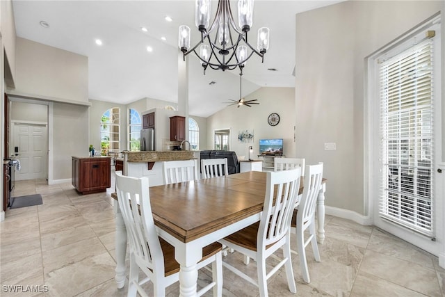 dining room with high vaulted ceiling, ceiling fan with notable chandelier, and light tile patterned flooring