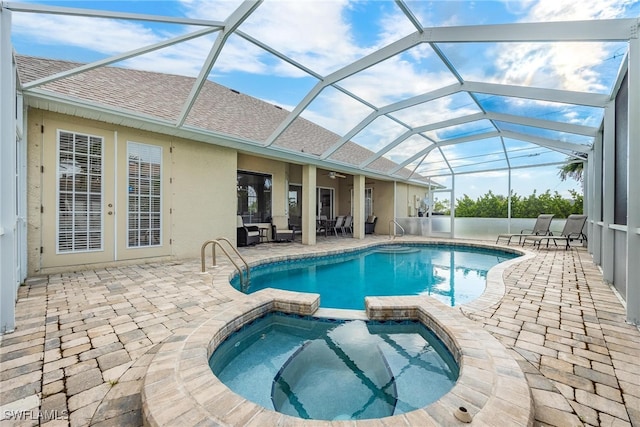 view of swimming pool featuring a lanai, an in ground hot tub, and a patio