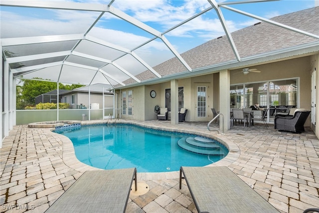 view of swimming pool with ceiling fan, a lanai, and a patio