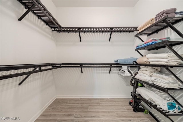 spacious closet with light hardwood / wood-style flooring