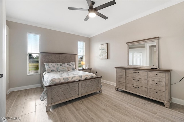 bedroom featuring light hardwood / wood-style flooring, ceiling fan, multiple windows, and ornamental molding