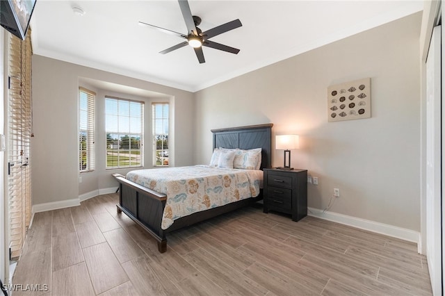 bedroom with ceiling fan, light hardwood / wood-style floors, and crown molding