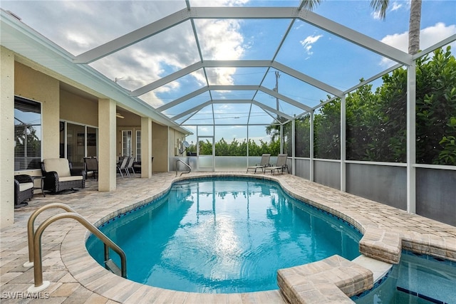 view of pool featuring glass enclosure and a patio area