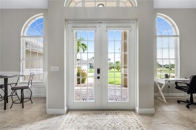 entryway with a wealth of natural light, french doors, and light tile patterned flooring