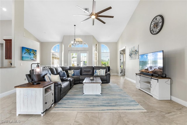 tiled living room featuring ceiling fan with notable chandelier and high vaulted ceiling