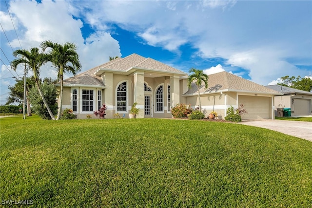 mediterranean / spanish house featuring a garage and a front lawn