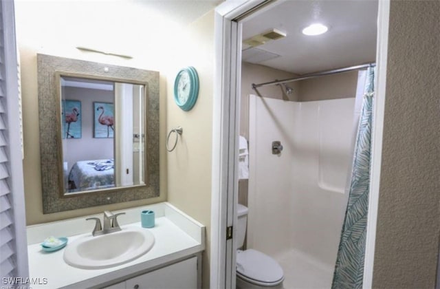 bathroom featuring toilet, walk in shower, and vanity