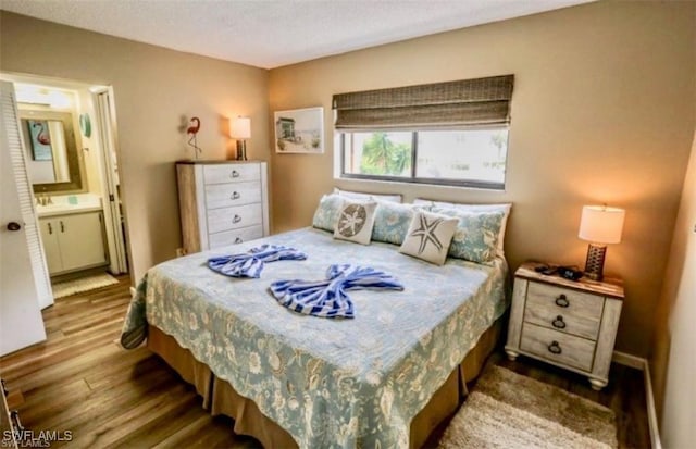 bedroom featuring a textured ceiling, hardwood / wood-style floors, and ensuite bathroom