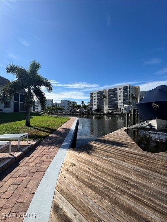 dock area featuring a lawn and a water view