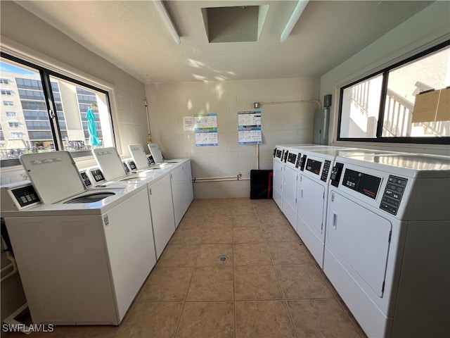 clothes washing area featuring light tile patterned flooring and independent washer and dryer