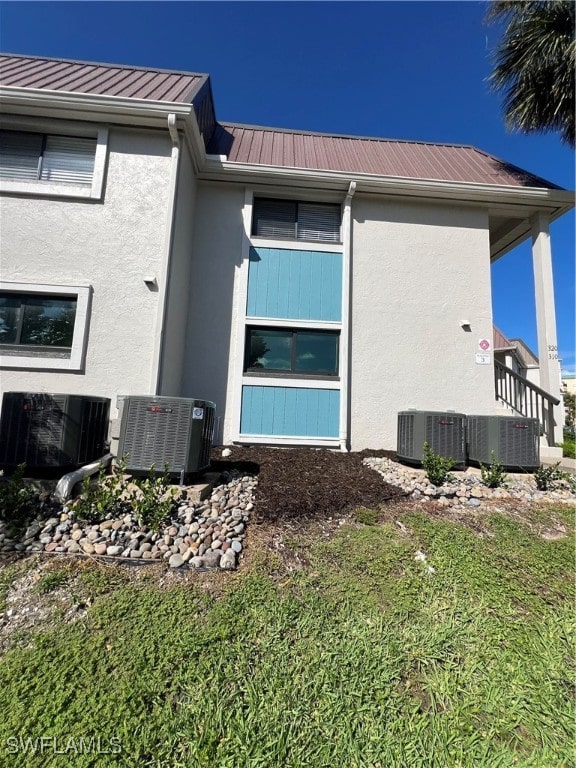 view of side of property with central air condition unit