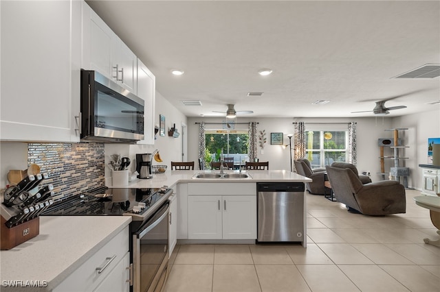 kitchen with ceiling fan, decorative backsplash, white cabinetry, and stainless steel appliances