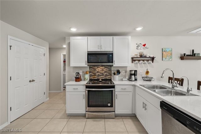 kitchen featuring sink, appliances with stainless steel finishes, tasteful backsplash, light tile patterned floors, and white cabinets