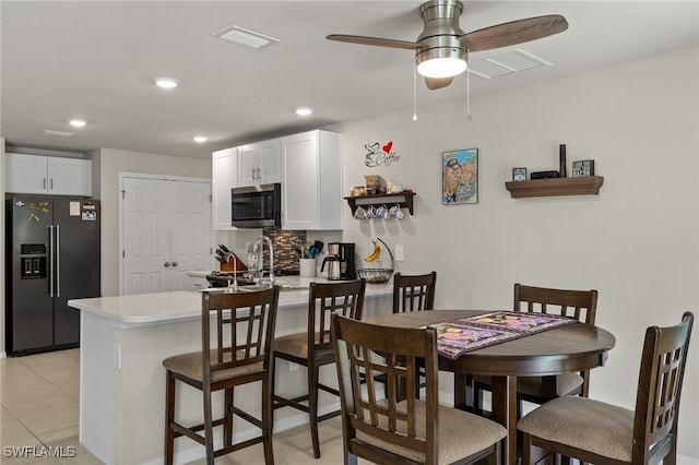 interior space with sink, ceiling fan, and light tile patterned floors