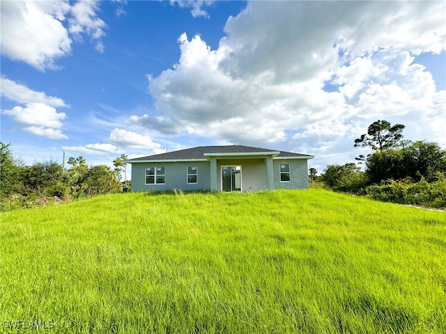 rear view of property featuring a yard